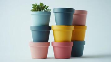 Colorful stacked plant pots with succulent against a light background photo