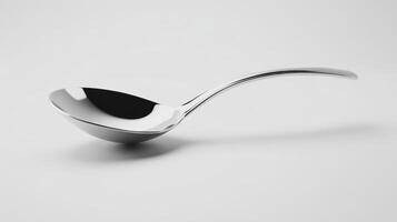 A shiny metal spoon resting on a clean white surface, showcasing its smooth curves and polished finish photo