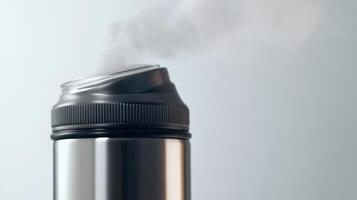 Hot steam rising from a stainless steel thermal mug filled with a warm beverage in a cozy indoor setting during winter photo