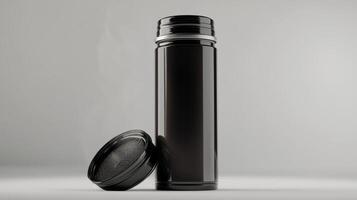 A sleek black thermos standing upright with its lid placed nearby against a minimalistic background photo
