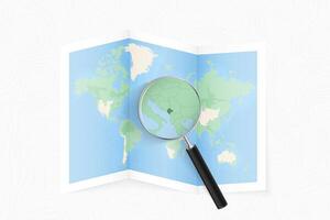 Enlarge Montenegro with a magnifying glass on a folded map of the world. vector