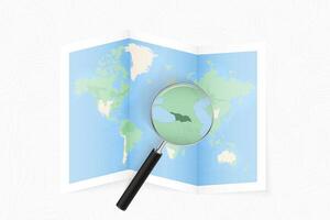 Enlarge Georgia with a magnifying glass on a folded map of the world. vector