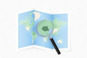 Enlarge Romania with a magnifying glass on a folded map of the world. vector