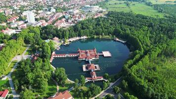 Aerial descending orbiting view of spa lake Heviz in Hungary in July 2024 video
