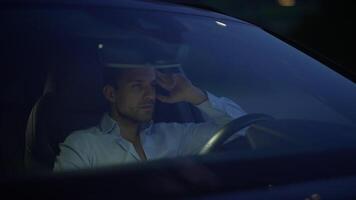 A contemplative man is sitting in his car during a quiet night, deep in thought and reflection video