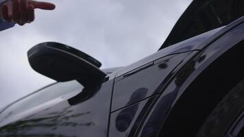 A closeup image showing a hand Charching Electric Car on Public Charching Station Using A Cable Connection video