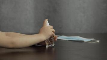Child using bottle of liquid alcohol spray sanitizer with hands. Coronavirus video
