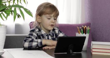 Girl doing online homework using digital tablet computer. Distance education video