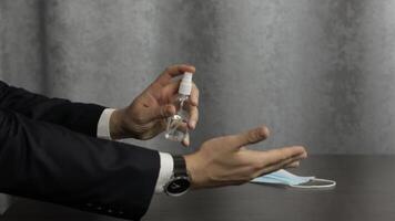 Man using bottle of liquid alcohol spray sanitizer with hands. Coronavirus video