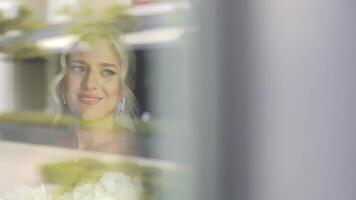 Bride smiling softly while looking out the window, A touching image of a bride gazing out the window with a soft smile, her expression reflecting calm and jo video