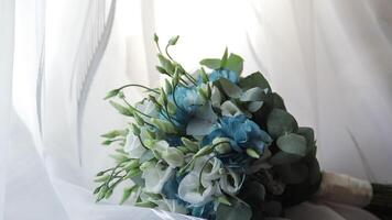 Beautiful wedding bouquet lie near window on white curtains video