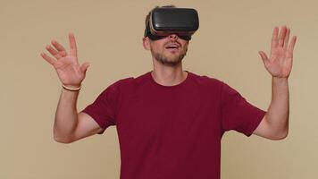 Young man using headset helmet app to play simulation drawing game watching virtual reality 3D video