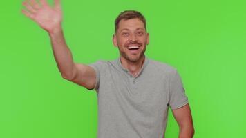 Bearded man appear from below waving hello with his palm, greeting with hospitable friendly smile video