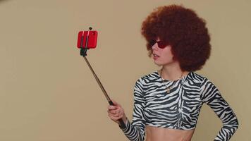 Impressed woman blogger taking selfie on mobile phone selfie stick, communicating call online video