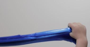 Child hands playing with oddly satisfying blue slime gooey substance. Antistress video