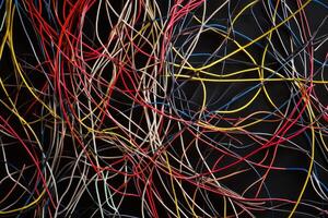 A tangled and chaotic arrangement of thin wires creating an intricate texture background photo