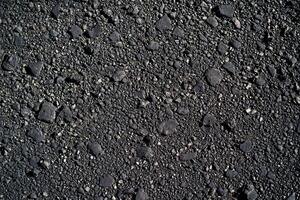 An asphalt texture background features a rough, gritty surface commonly seen on roadways photo