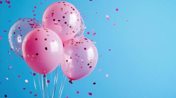 Pink balloons filled with confetti on a blue background photo