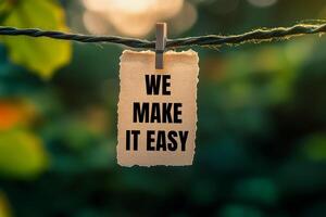 We make it easy message written on paper hung with clothespins. Conceptual we make it easy symbol. Copy space. photo