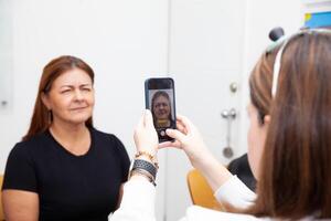 Expression of anger. Photographic record. Dermatologist taking pictures to a middle age female patient prior to application of Botulinum toxin injections. Aesthetic medicine. photo