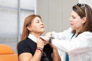 Dermatologist preparing a middle age female patient for botulinum toxin application. Aesthetic medicine photo