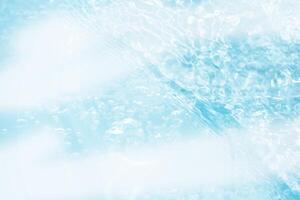 Blue water with ripples on the surface. Defocus blurred transparent blue colored clear calm water surface texture with splashes and bubbles. Water waves with shining pattern texture background. photo