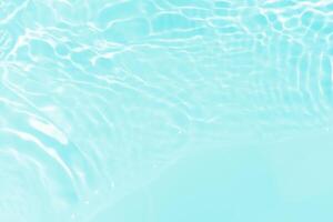 Blue water with ripples on the surface. Defocus blurred transparent blue colored clear calm water surface texture with splashes and bubbles. Water waves with shining pattern texture background. photo