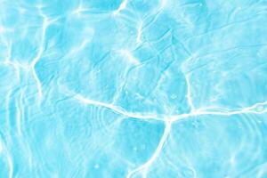 Bluewater waves on the surface ripples blurred. Defocus blurred transparent blue colored clear calm water surface texture with splash and bubbles. Water waves with shining pattern texture background. photo