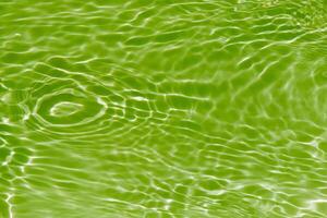 Bluewater waves on the surface ripples blurred. Defocus blurred transparent blue colored clear calm water surface texture with splash and bubbles. Water waves with shining pattern texture background. photo