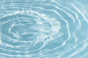 Bluewater waves on the surface ripples blurred. Defocus blurred transparent blue colored clear calm water surface texture with splash and bubbles. Water waves with shining pattern texture background. photo