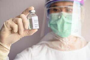 Scientist doctor holding a sample test bottle of Covid-19 vaccine. photo