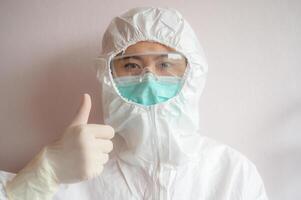 Nurse wearing PPE suit with mask for protect virus and showing thumbs up. photo