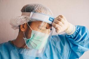 Doctor having headache and tired from work while wearing PPE suit for protect coronavirus disease. photo