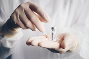 Scientist doctor hand holding a sample test bottle of Covid-19 vaccine. photo