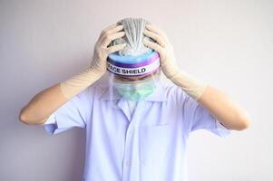 Portrait of Nurse or Doctor having headache and stress from working. The wellbeing and emotional resilience are key components of maintaining essential care services during the COVID-19 pandemic. photo