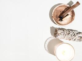 Items for spiritual cleansing - sage bundle, palo santo incense sticks and candle on white background. photo