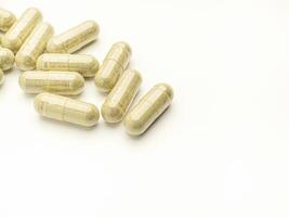 Flat lay of Andrographis paniculata capsules isolated on white background. Space for text. Herbal, medicine, and healthcare concept photo