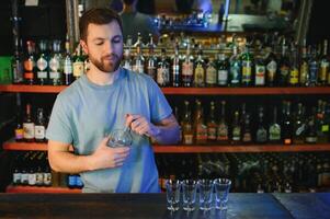 Handsome bar tender standing behind his counter in a pub photo