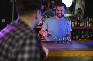 Handsome bar tender standing behind his counter in a pub photo