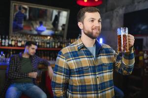 Night in bar. Portrait of cheerful men drinking beer at the bar photo