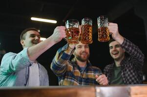 Soccer fans at the bar. Happy football fans cheering at bar and drinking beer while bartender serving beer at the background photo