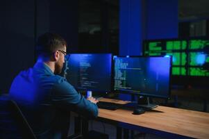Night Office Young Handsome Man in Working on Desktop Computer. Digital Entrepreneur Typing Code photo