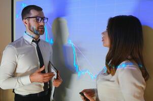 Group of business people working. Technical price graph and indicator, red and blue candlestick chart and stock trading computer screen background. Traders analyzing data photo