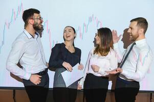 Group of business people working at modern office.Technical price graph, red and blue candlestick chart and stock trading computer screen background. Double exposure. Traders analyzing data photo