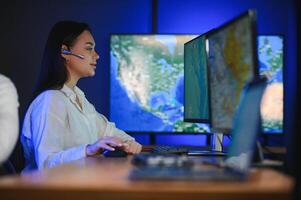Friendly smiling woman call center operator with headset using computer at office photo