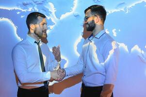 Handshake with map of the world in background photo