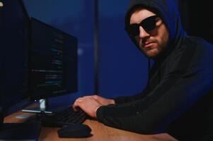 Programmer or computer hacker typing code photo