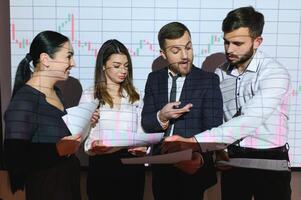 Analyzing data, graphs and reports for investment purposes. Creative teamwork traders. photo