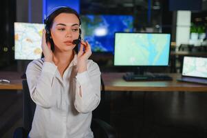 Friendly smiling woman call center operator with headset using computer at office photo