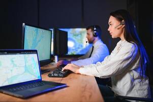 Center of dispatching maintenance. Portrait of cheerful woman and man working via headset microphone while sitting on navigation controller board photo